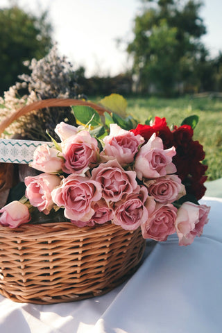 Roses on a picnic blanket in a wicker basket